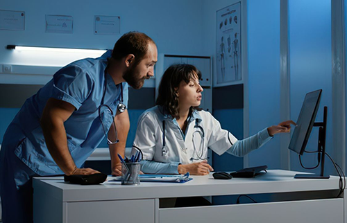 Nurses reviewing hydrocephalus brain scans on computer