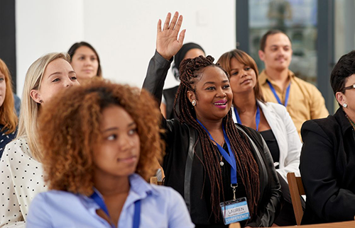 Conference attendee raising hand and asking questions at neuroscience conference