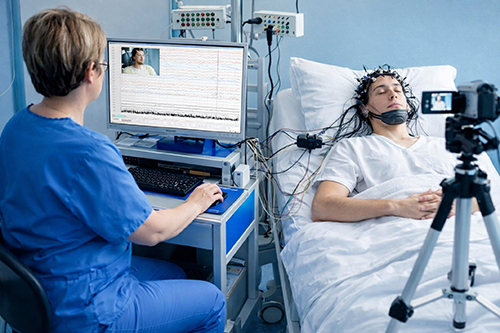 Nurse monitors a patient undergoing video EEG